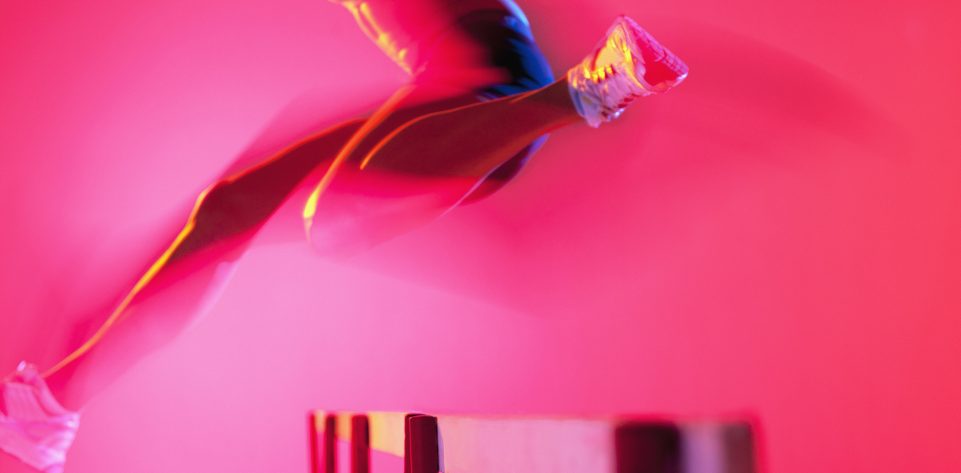 Blurred view of athlete jumping hurdle