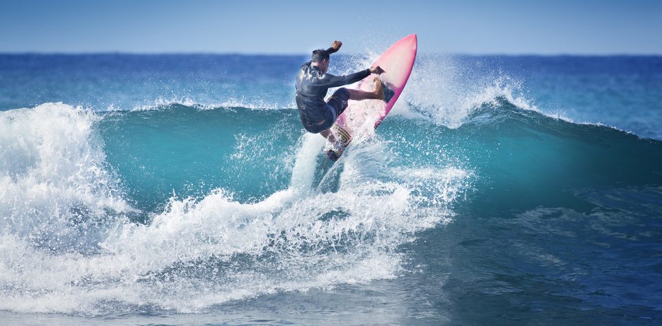 Young surfer surfing the wave of Kauai, Hawaii, USA.